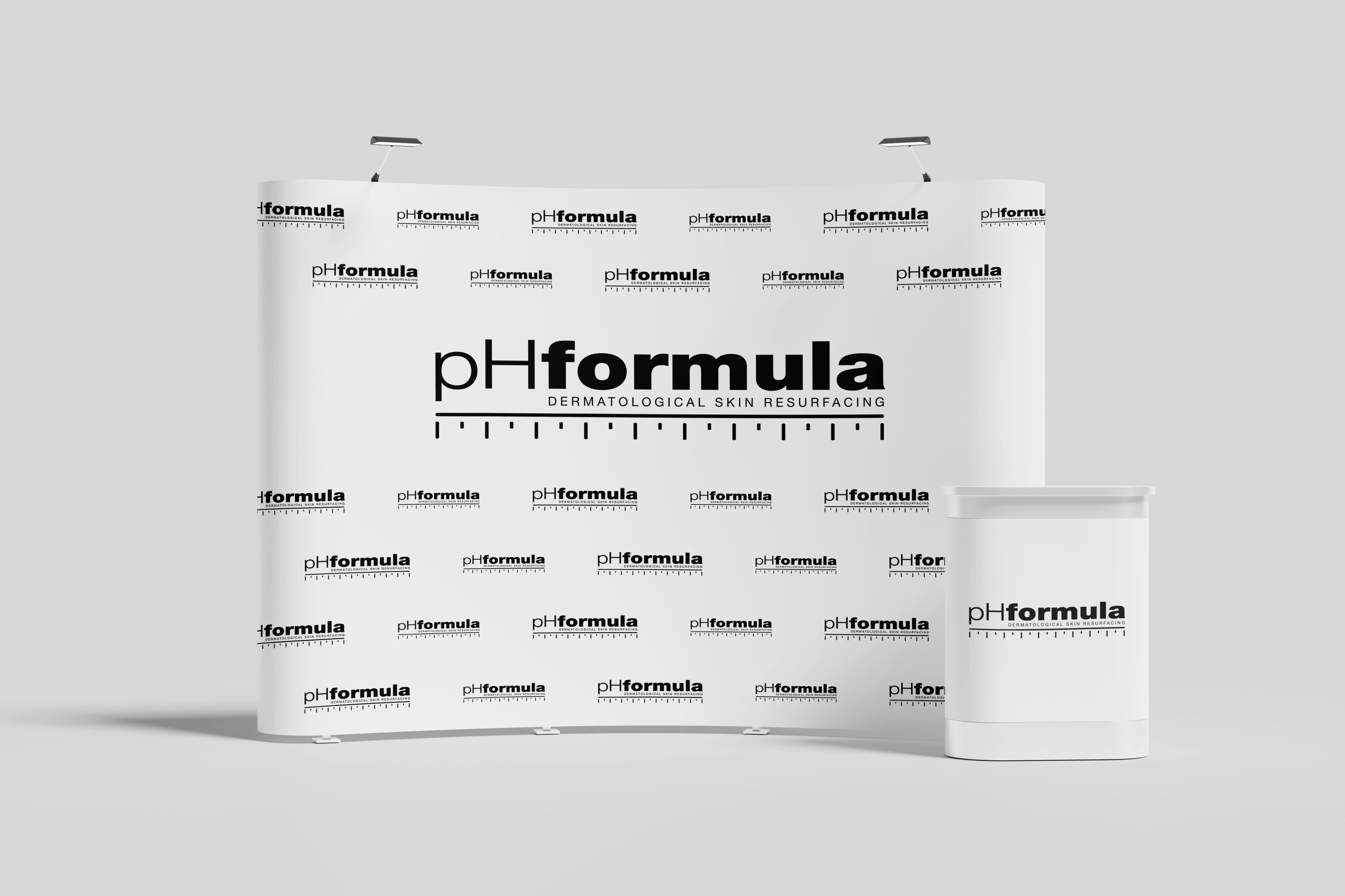 Biela reklamná fotostena pHformula s opakujúcim sa čiernym logom značky a zodpovedajúcim prezentačným pultom.
