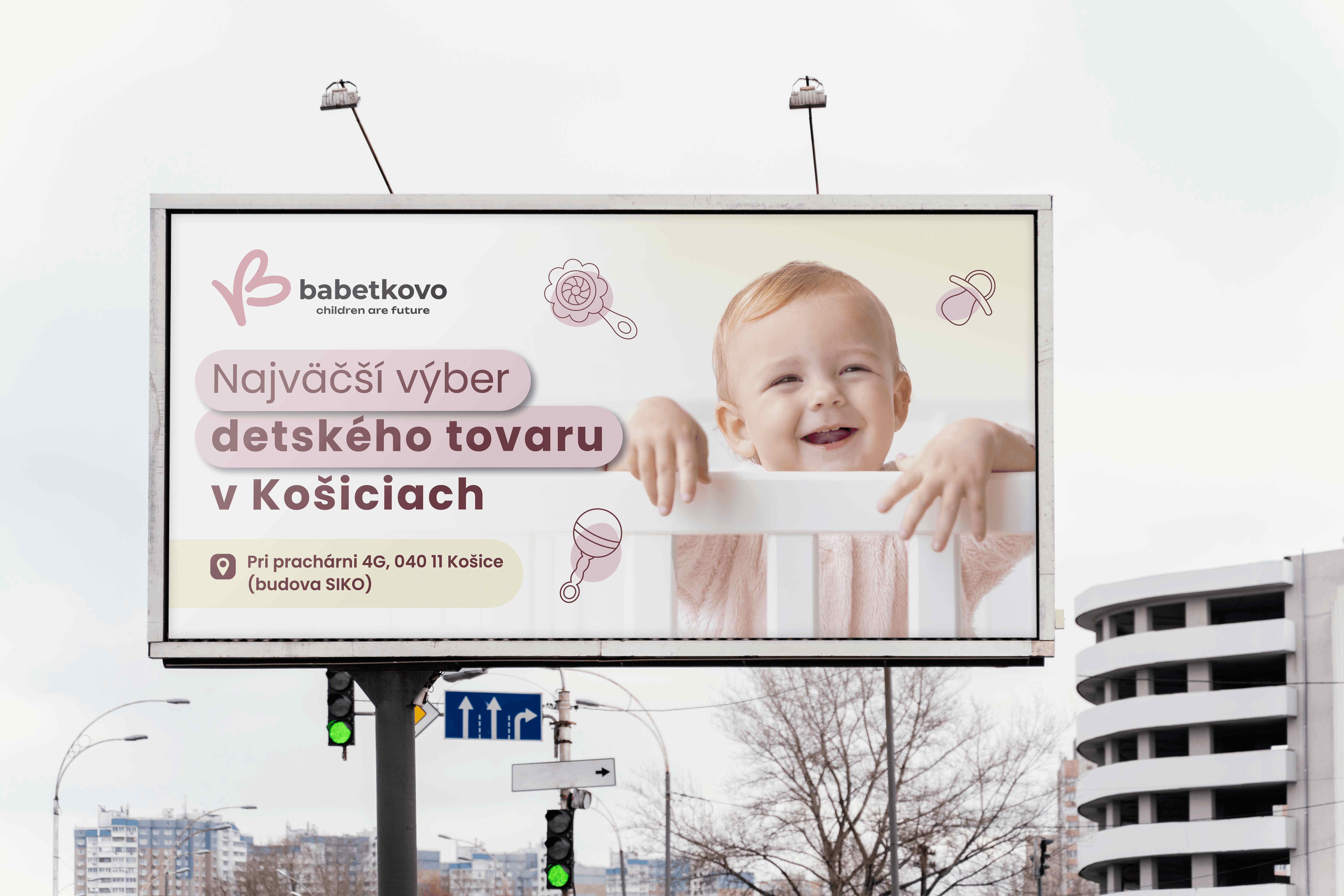 Reklamný billboard BABETKOVO s fotografiou usmiateho bábätka, ružovými grafickými prvkami a informáciou o predaji detského tovaru v Košiciach.
