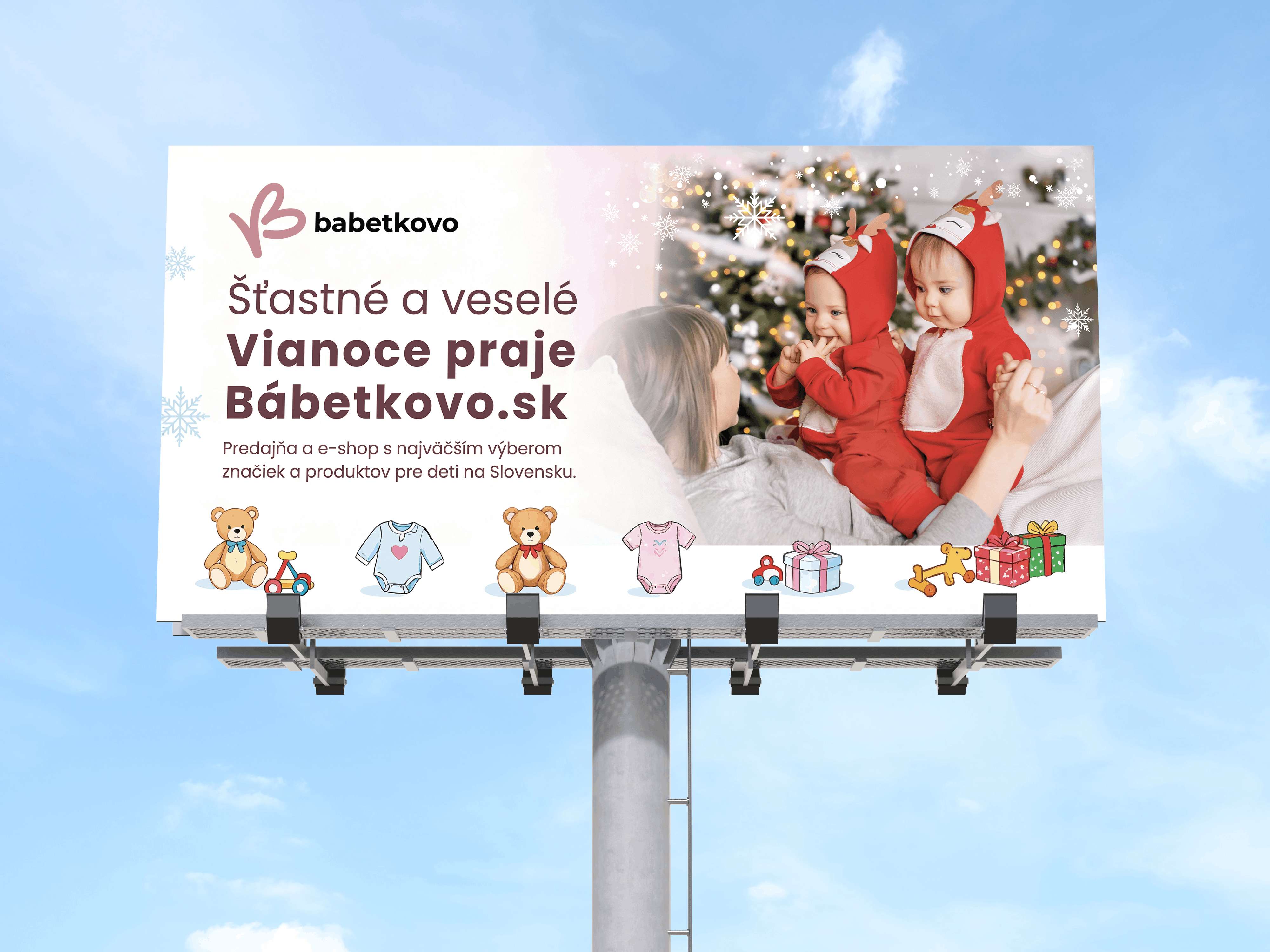 Vianočný reklamný billboard BABETKOVO s fotografiou dvoch detí v červených vianočných kostýmoch, sviatočnými ilustráciami a vianočným prianím.