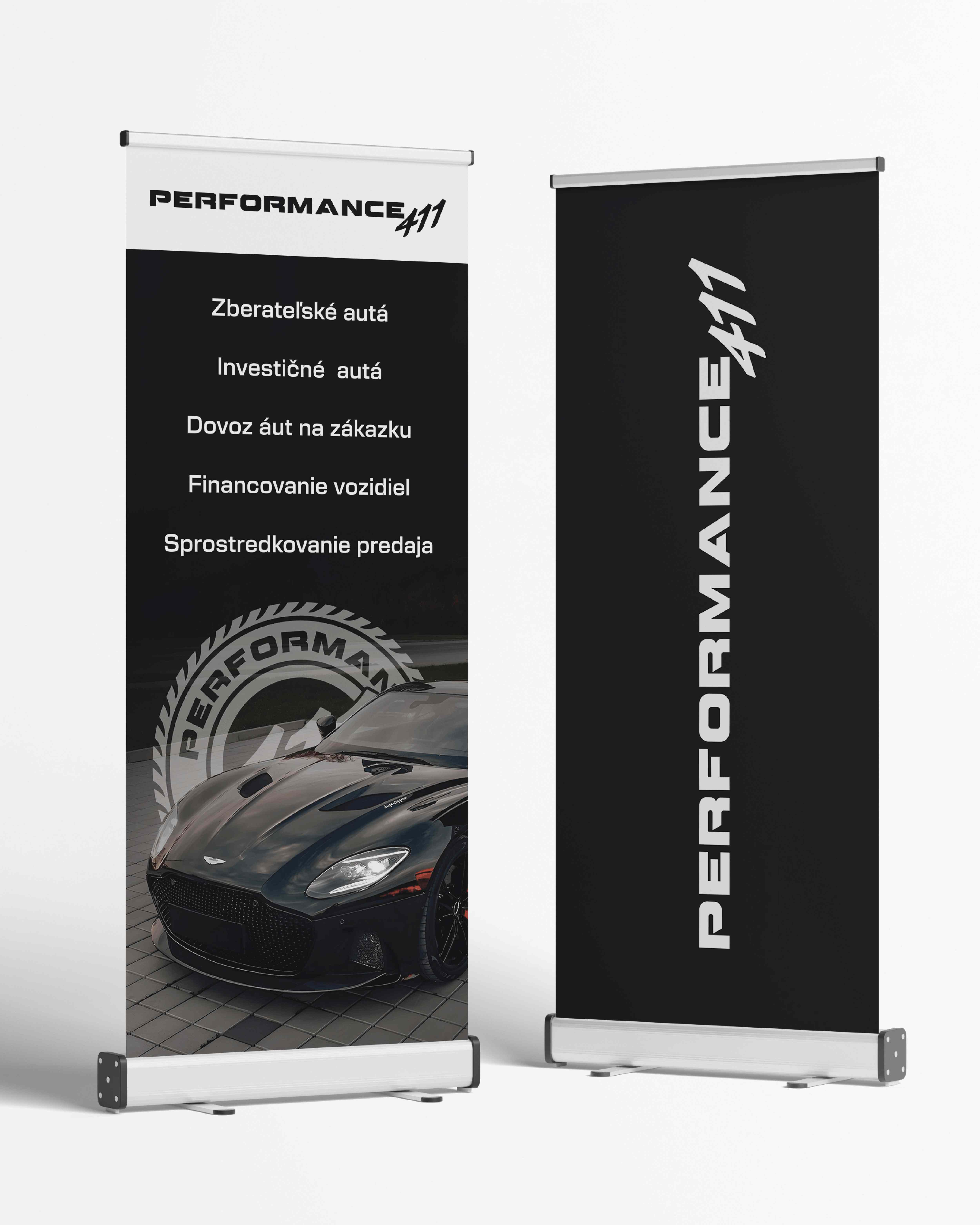 Dva čierne reklamné roll-up bannery Performance 411 s fotografiou športového automobilu, logom a informáciami o automobilových službách.