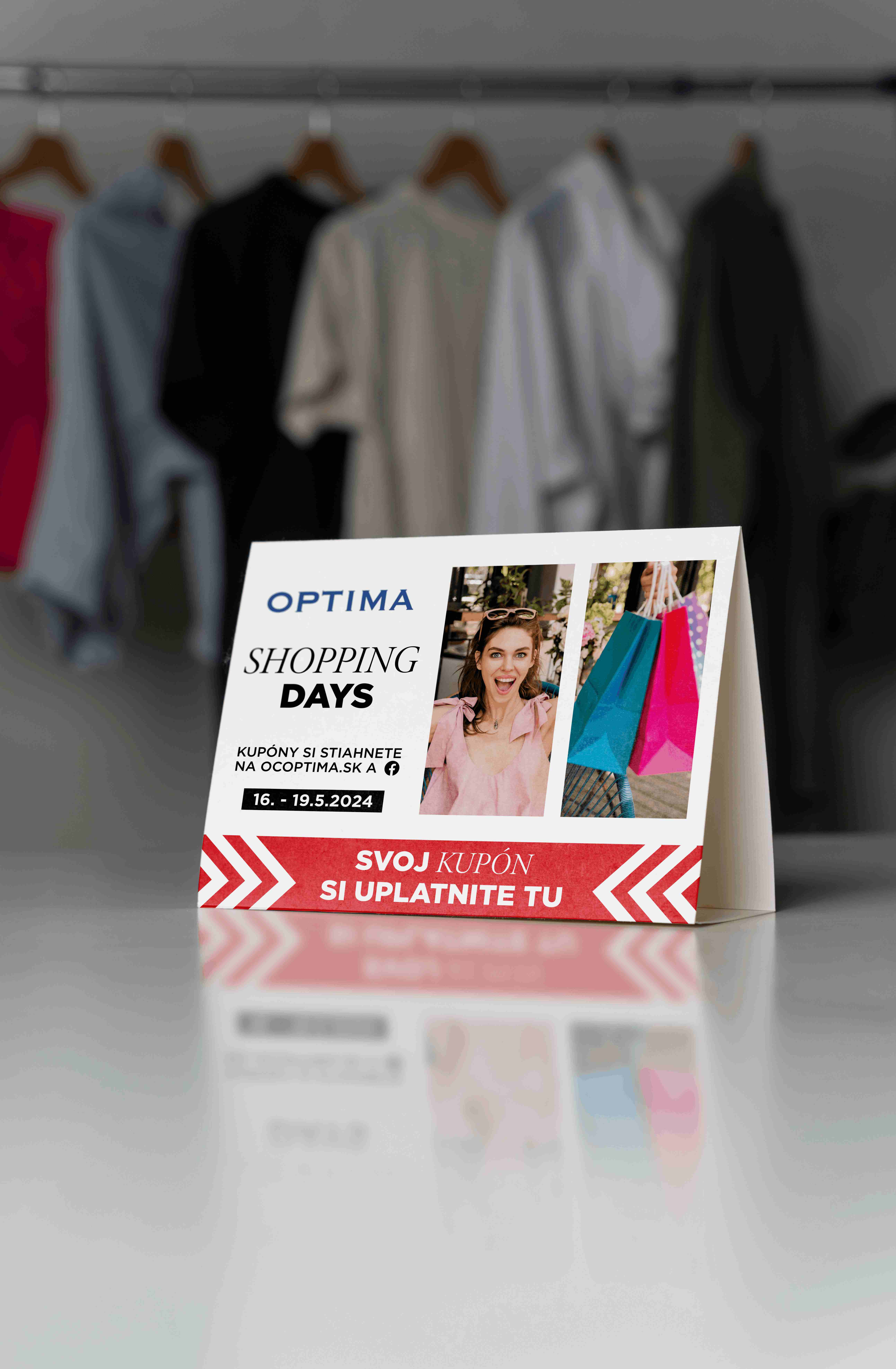 Stolový reklamný stojan OC Optima Shopping Days s fotografiou ženy, farebnými nákupnými taškami a termínom 16. – 19. septembra 2024.