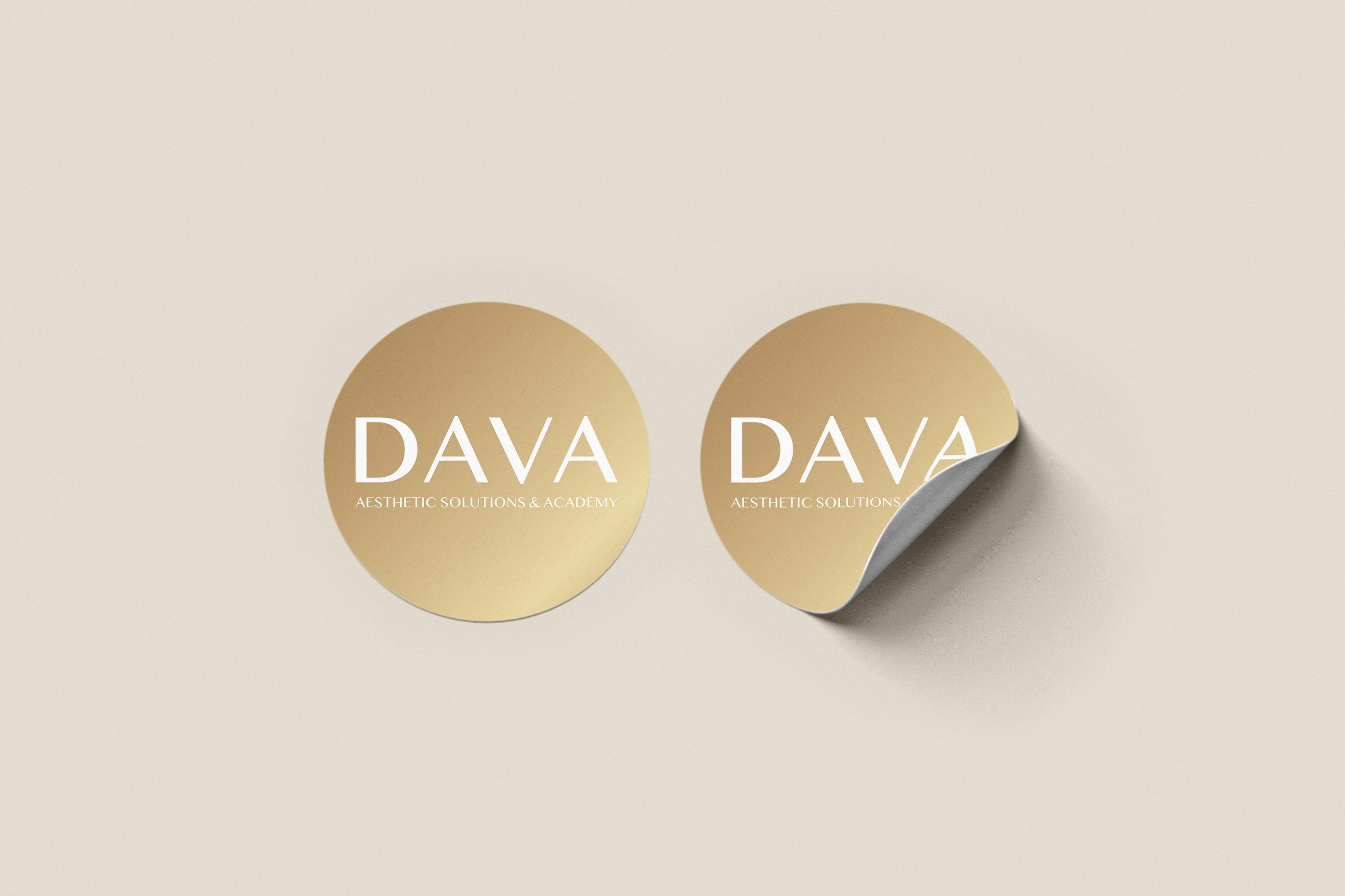 Okrúhle značkové nálepky DAVA Aesthetic Solutions & Academy v zlatom farebnom prevedení s bielym logom a minimalistickým dizajnom.