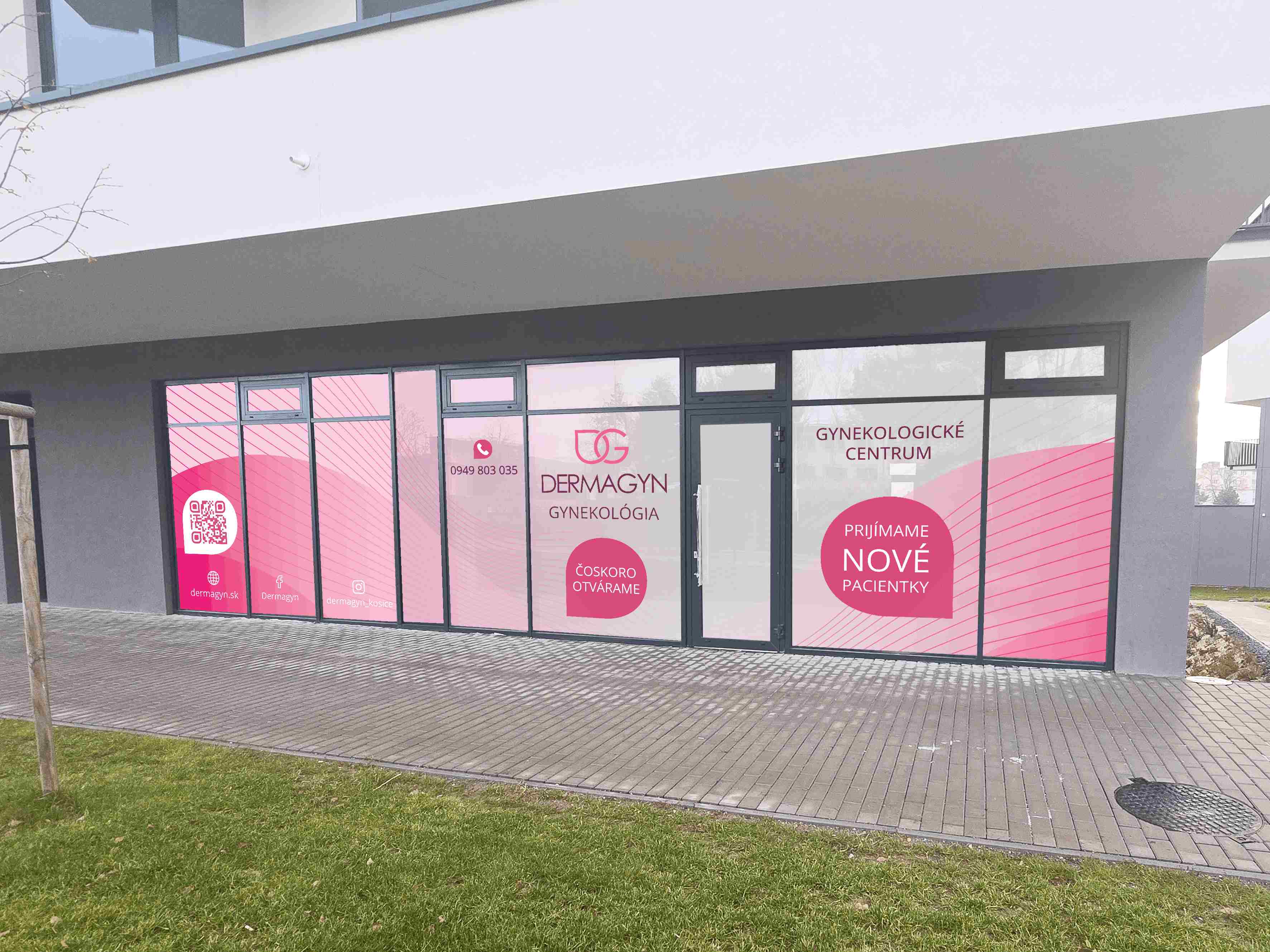 Ružovo-biely polep preskleného výkladu gynekologického centra DERMAGYN s logom, kontaktnými údajmi a informáciou o prijímaní nových pacientok.