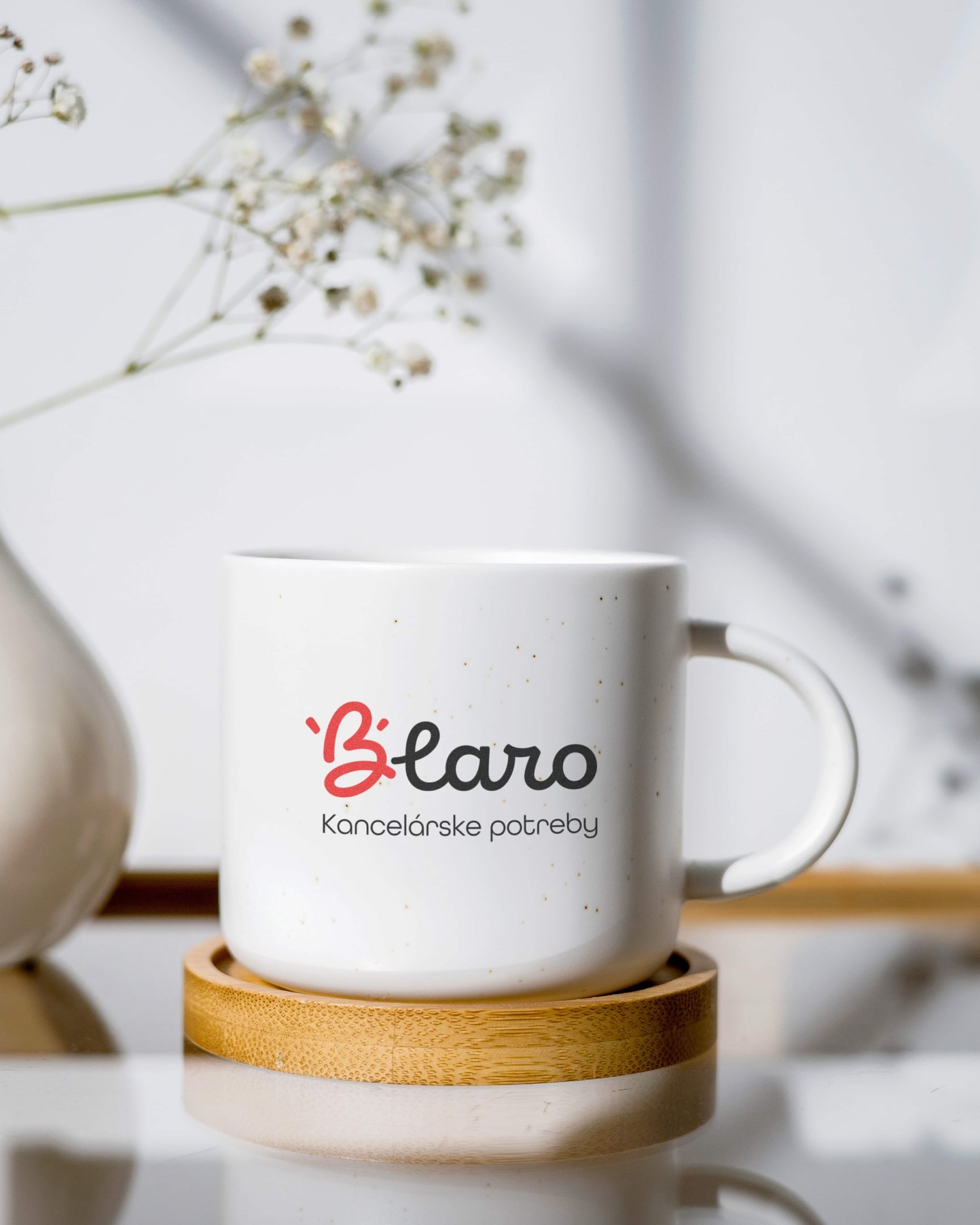 Minimalistické logo BLARO s upraveným písmenom B použité ako branding na keramickom hrnčeku.