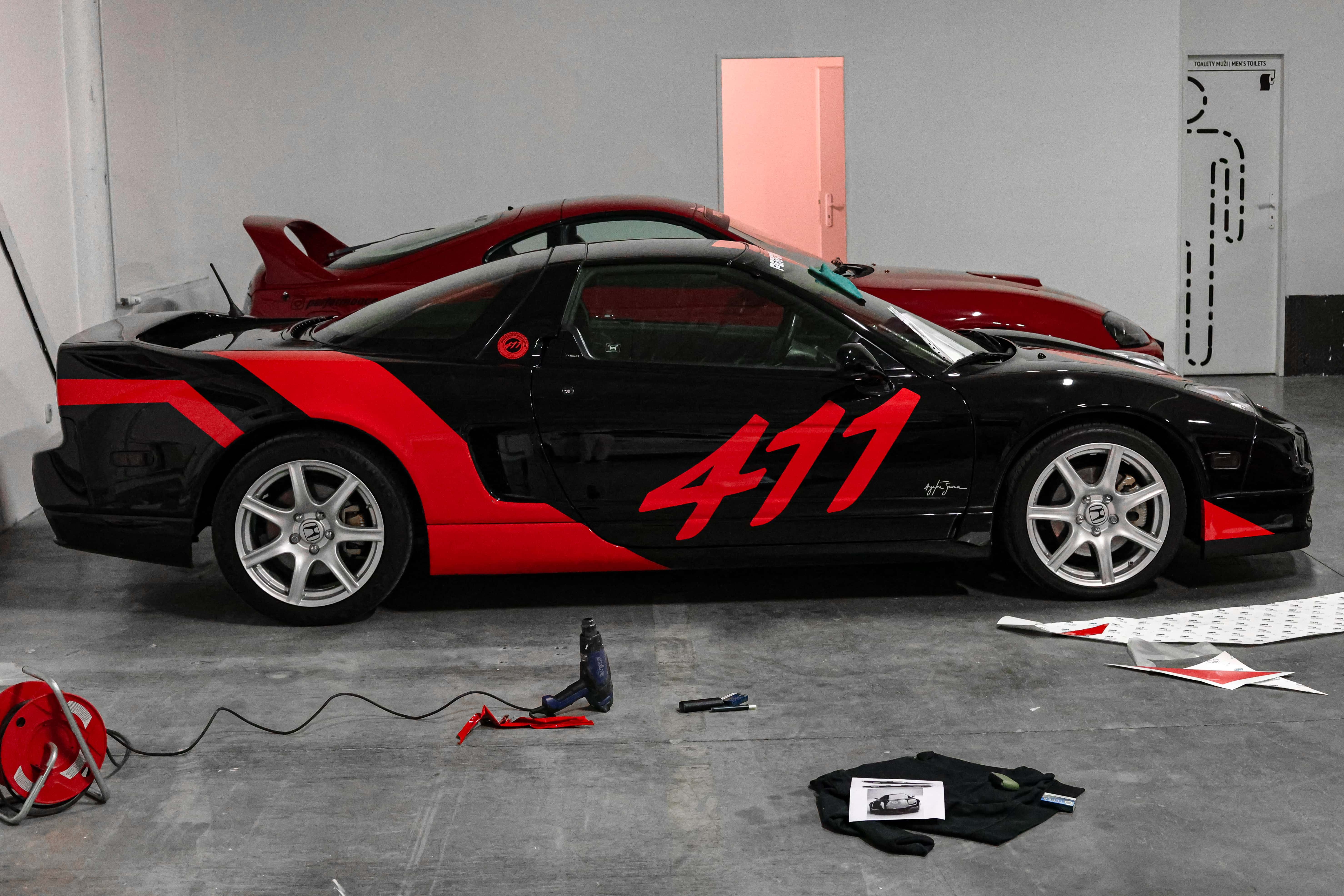 Pohľad na bok vozidla honda polepený červenou fóliou s logom 411.