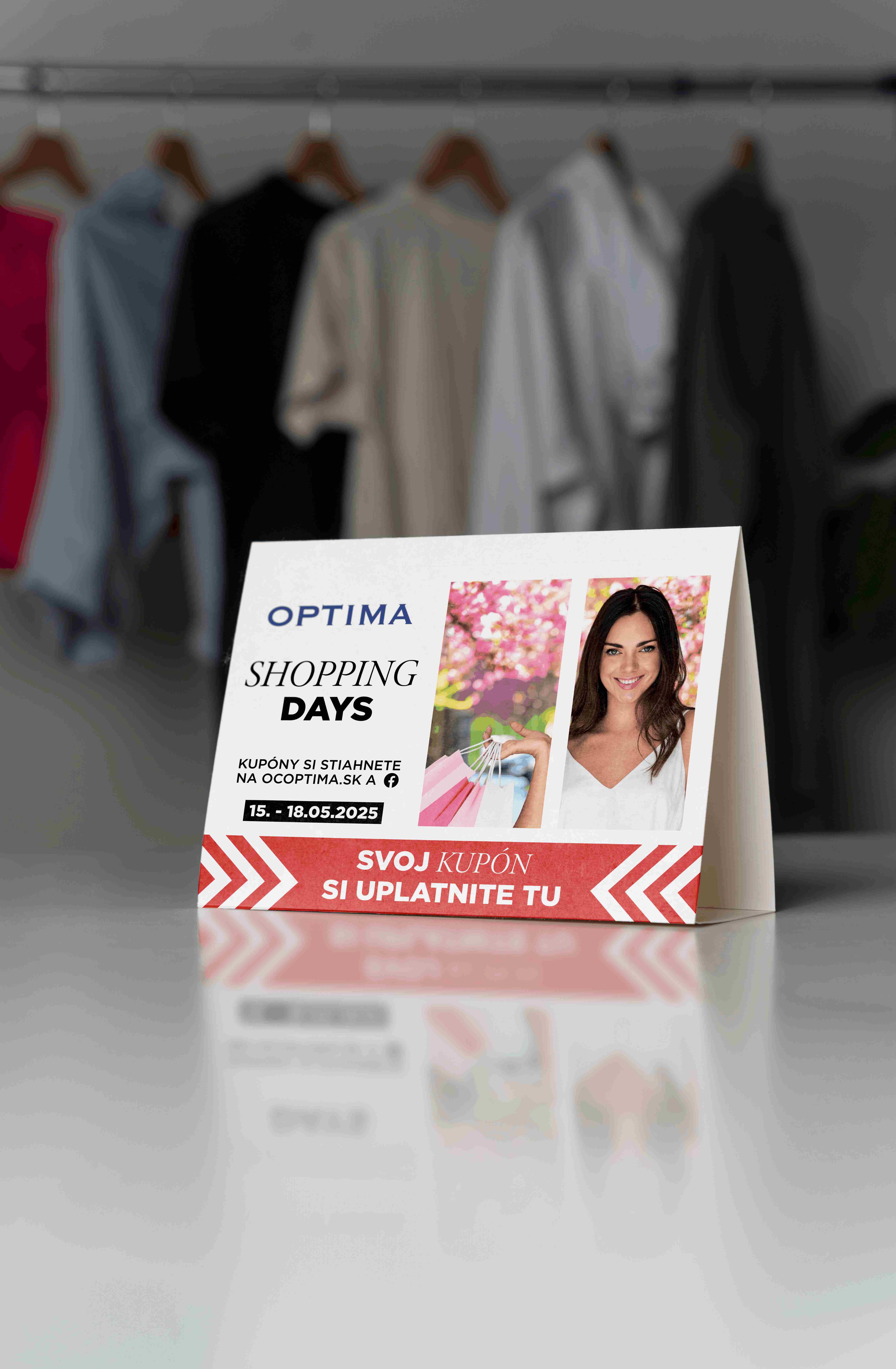 Stolový reklamný stojan OC Optima Shopping Days s fotografiou ženy, červenými grafickými prvkami a informáciou o uplatnení nákupného kupónu.