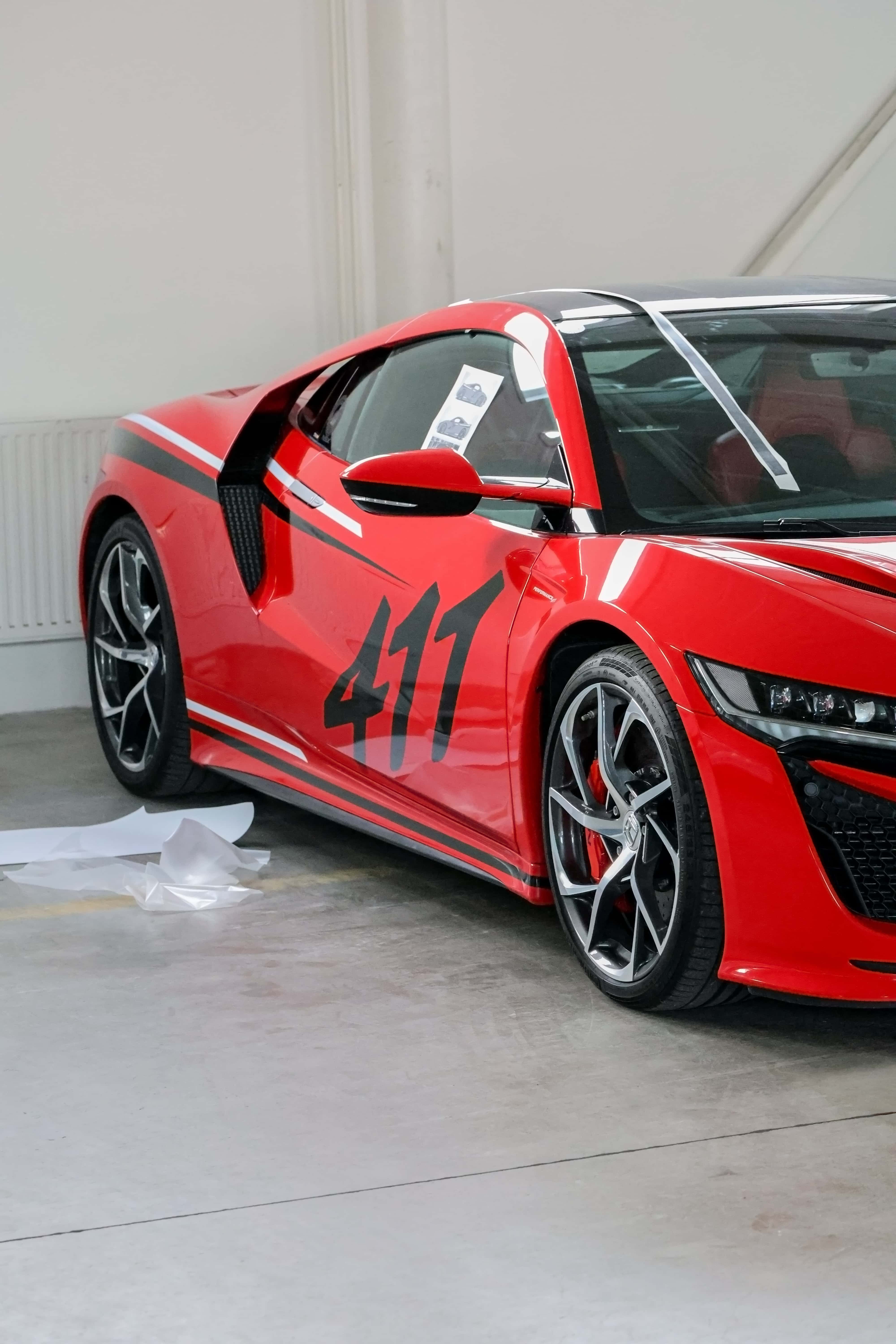 Pohľad z boku na červenú hondu nsx.